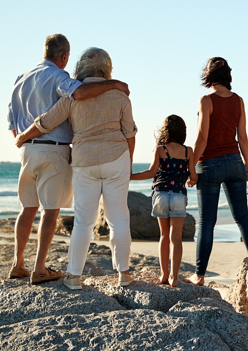 family at the beach looking out towards the water