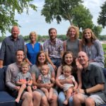 large family posing in front of trees