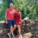 two people posing in front of a stone wall