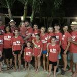 family posing near pool wearing red Thrivent shirts