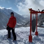 man posing near gong in snowy mountains